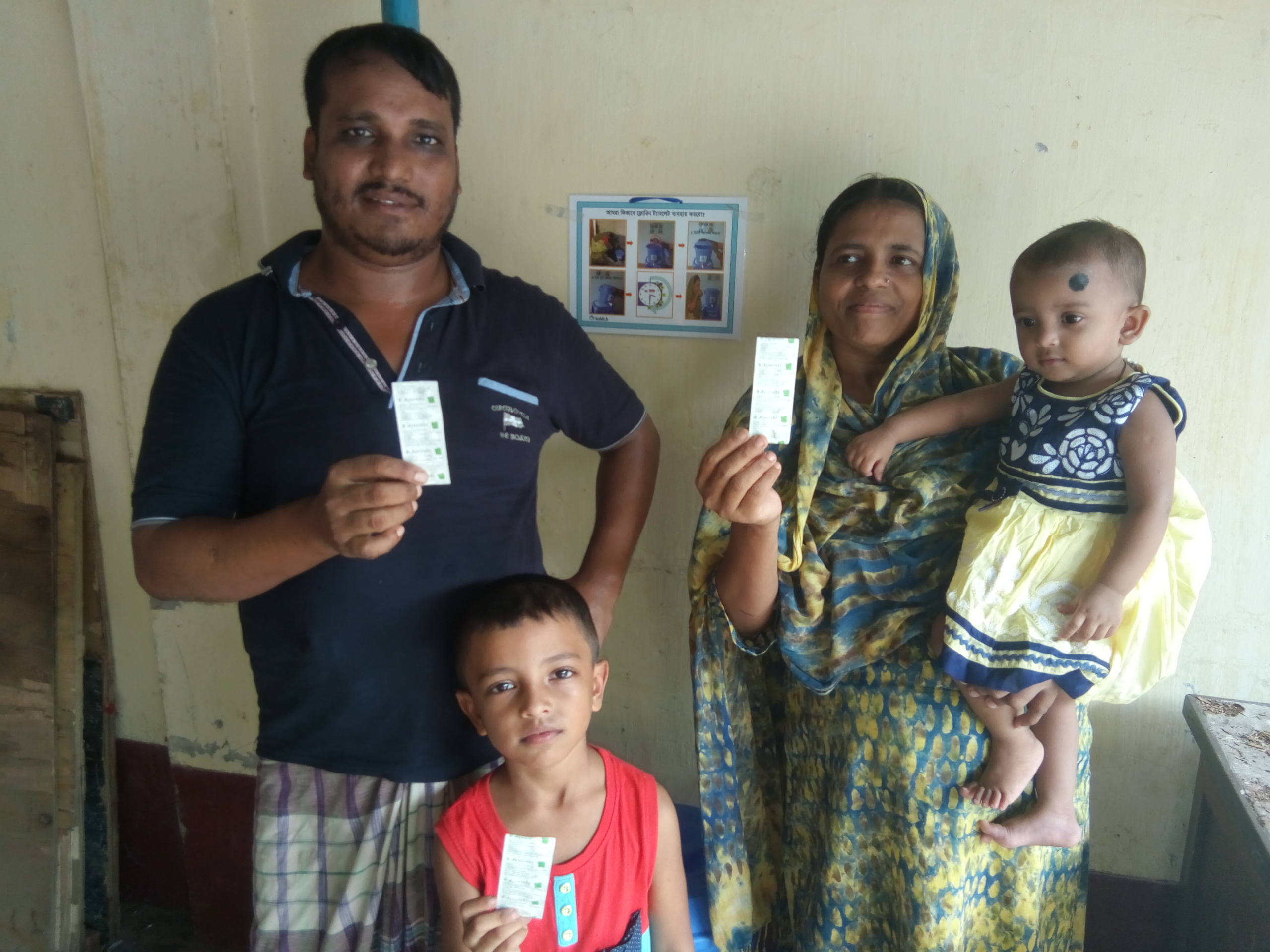 A family in Bangladesh holding Aquatabs water purification tablets.