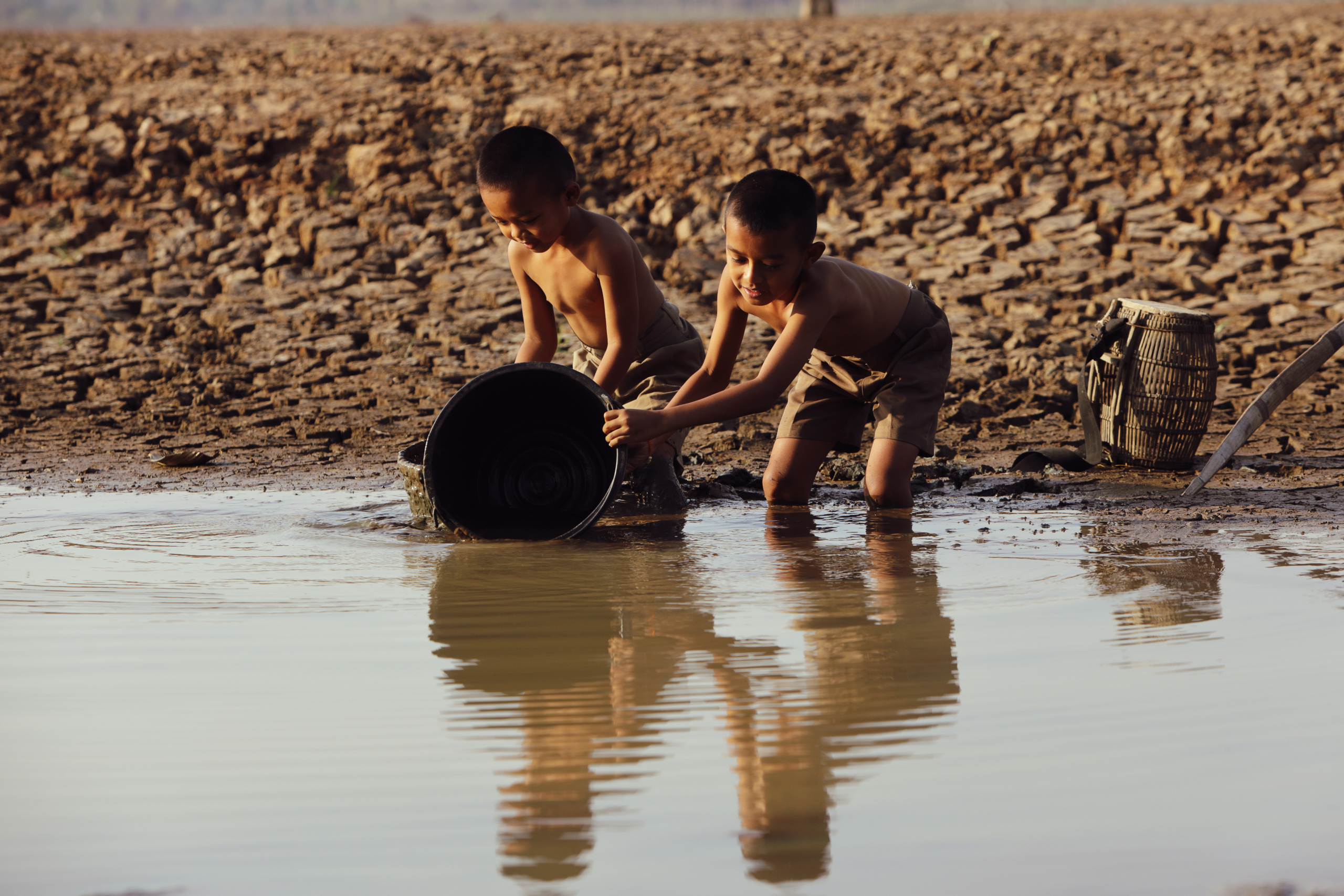 Children collecting water from a scarce source, illustrating the need for safe water Myanmar earthquake aid.