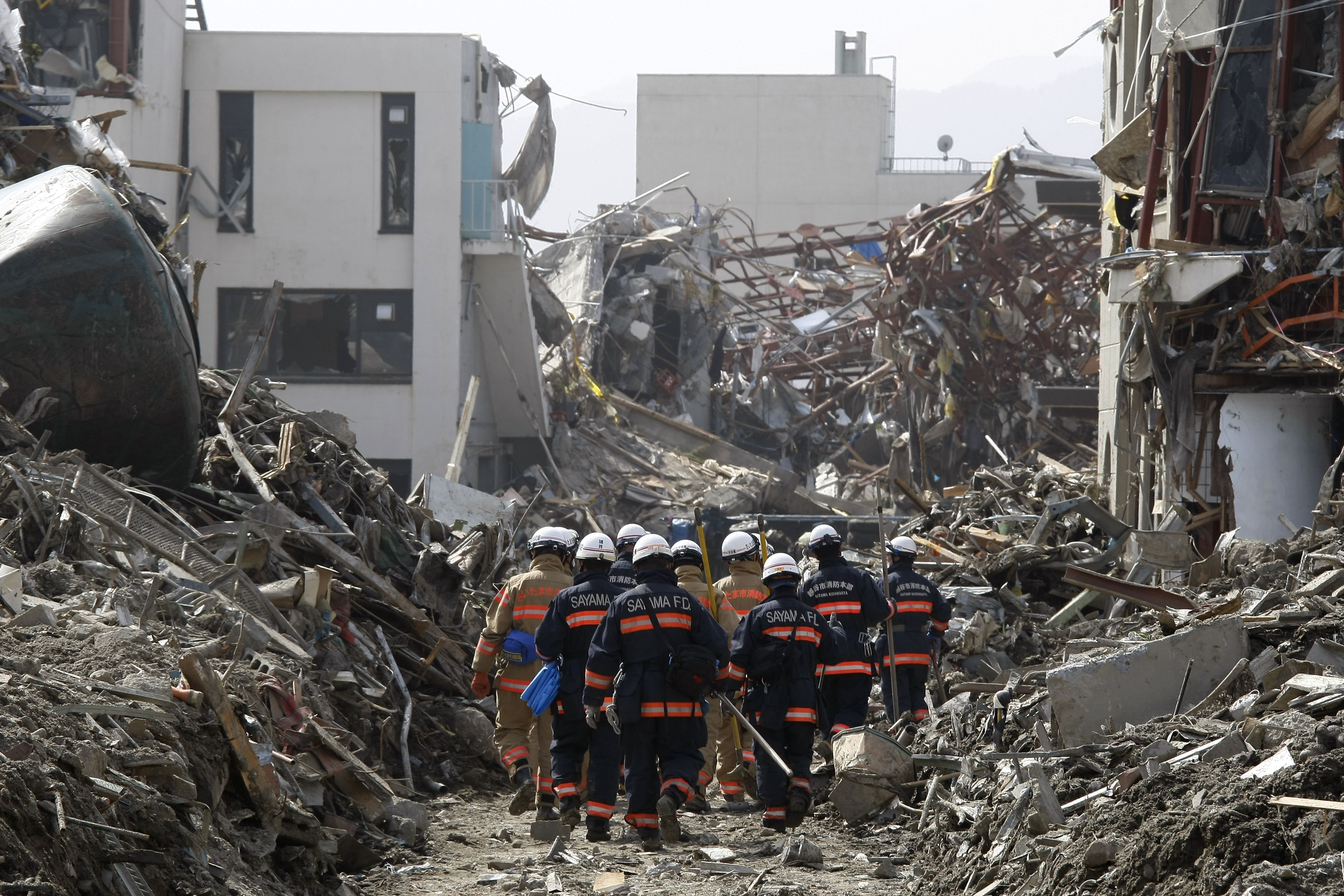 Rescue workers amidst earthquake rubble in Myanmar, highlighting the disaster impacting safe water access.