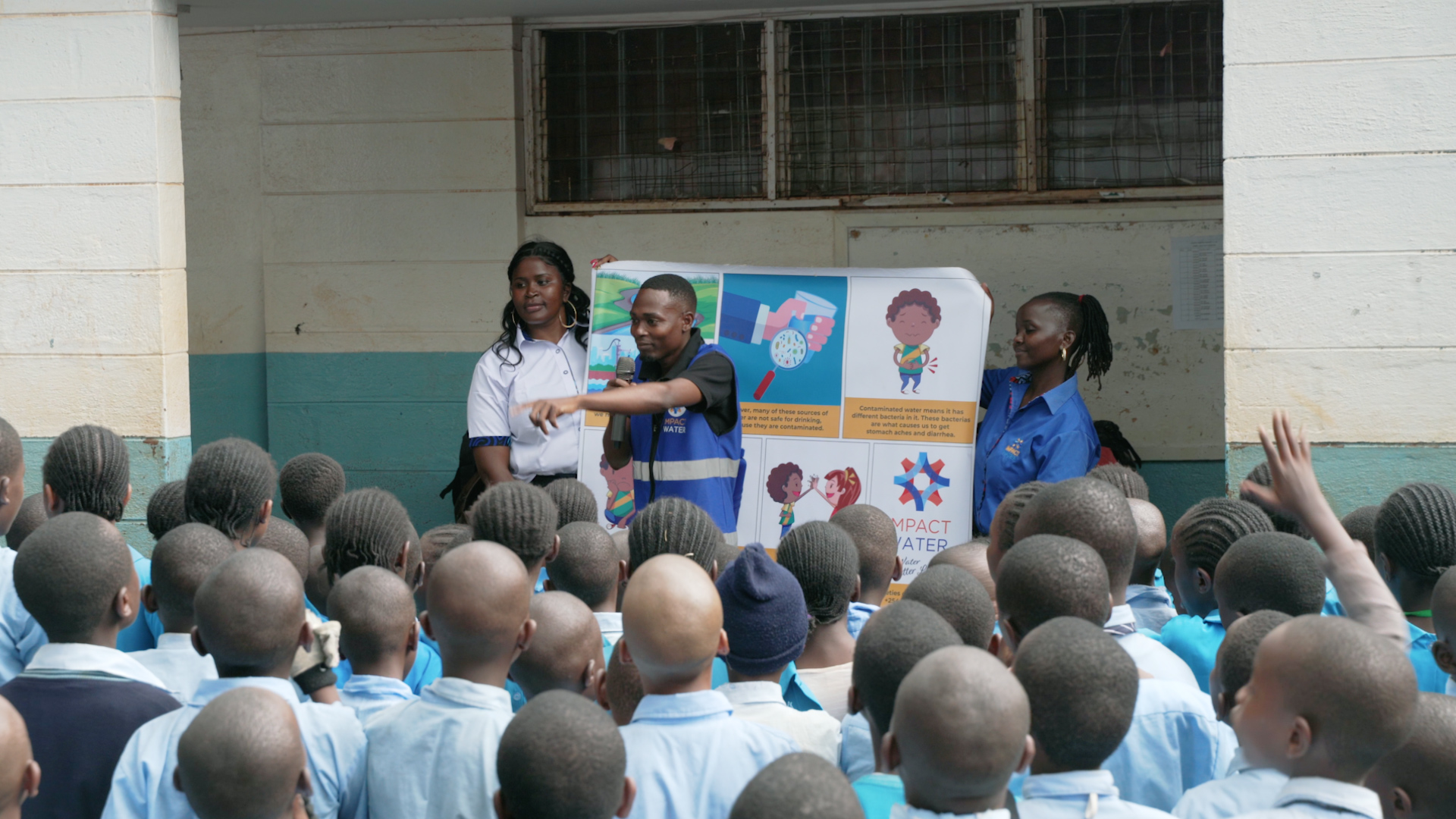 Aid workers conducting a WASH (Water, Sanitation, and Hygiene) education session for a group of schoolchildren in Kenya.